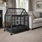 Steel dog crate with roof and wheels placed indoors next to a sofa in a living room setting