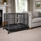 Steel dog crate with wheels placed indoors next to a sofa in a living room setting